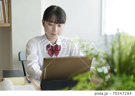 自宅でリモート授業を受ける女子高生 70347284