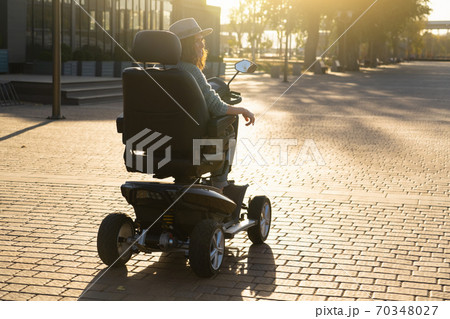 Woman riding an electric scooter Woman riding an electric scooter 70348027