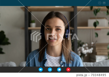 Young Caucasian woman in headphones speak on video call 70348495