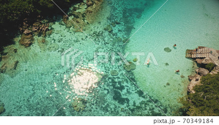 Top down sun reflecting, sparkling at emerald salt water lake. People swim, play in tropical lagoon Top down sun reflecting, sparkling at emerald salt water lake. People swim, play in tropical lagoon 70349184