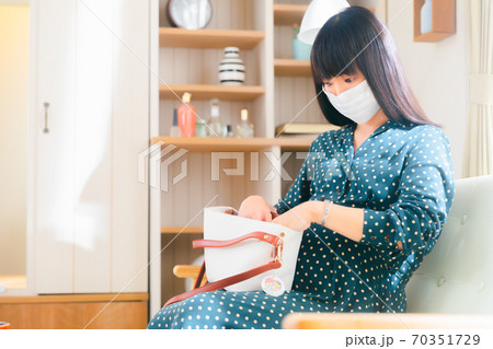 鞄に手を入れる妊婦　 70351729