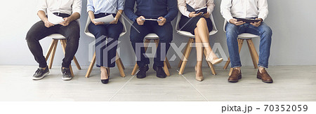 Group of unrecognizable candidates sitting on chairs waiting for an interview. Group of unrecognizable candidates sitting on chairs waiting for an interview. 70352059