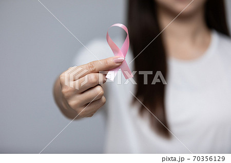 woman holding pink ribbon to support breast cancer awareness month for fight with cancer 70356129