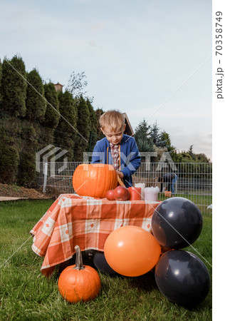 A young man leans on a shiny column. Courageous guy with a firefighter tattoo on his biceps. Male portrait. A young man leans on a shiny column. Courageous guy with a firefighter tattoo on his biceps. Male portrait. 70358749