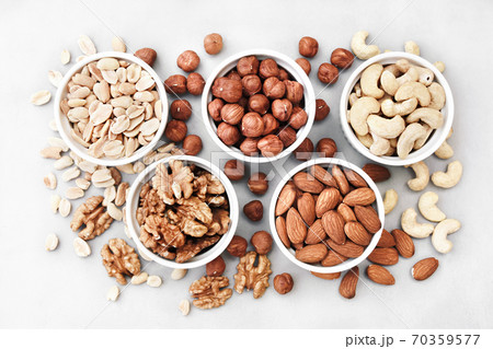 Colorful mix of various nuts: peanut and cashew, hazelnut and almond, pine nuts and walnut; healthy diet snack; vegan food background Colorful mix of various nuts: peanut and cashew, hazelnut and almond, pine nuts and walnut; healthy diet snack; vegan food background 70359577