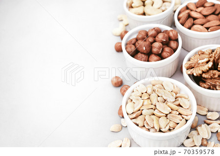 Colorful mix of various nuts: peanut and cashew, hazelnut and almond, pine nuts and walnut; healthy diet snack; selective focus, shallow DOF Colorful mix of various nuts: peanut and cashew, hazelnut and almond, pine nuts and walnut; healthy diet snack; selective focus, shallow DOF 70359578