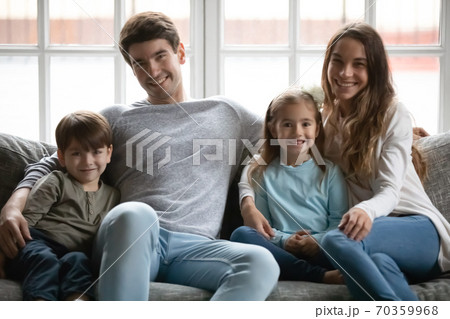 Portrait of happy young family with kids on couch Portrait of happy young family with kids on couch 70359968
