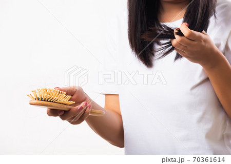 Woman weak hair her hold hairbrush with damaged long loss hair in comb brush on hand Woman weak hair her hold hairbrush with damaged long loss hair in comb brush on hand 70361614