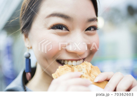 たい焼きを食べる女性 70362603