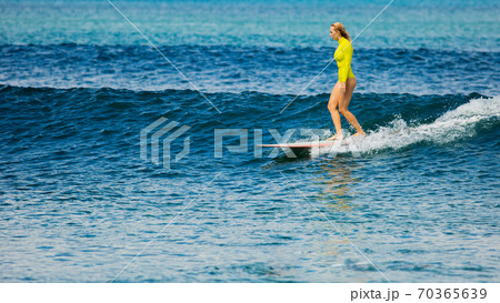beautiful surfer girl rides a longboard 70365639