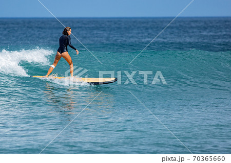 beautiful surfer girl rides a surfboard 70365660