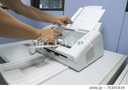 hand man are using a fax machine in the office, equipment for data transmission. 70365836