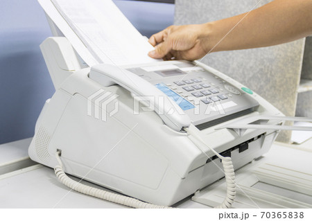 hand man are using a fax machine in the office, equipment for data transmission. 70365838