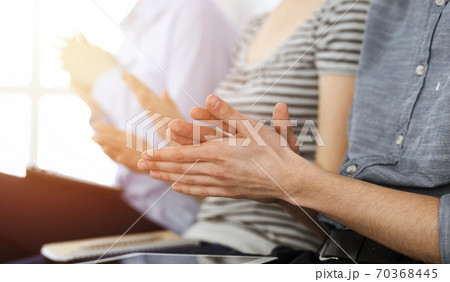 Business people clapping at meeting or conference, close-up of hands. Group of unknown businessmen and women in sunny office 70368445