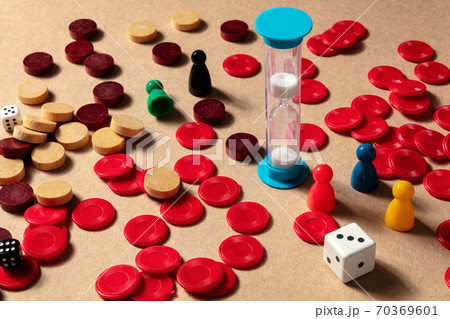 Game night concept, an hourglass with pawns and dice 70369601