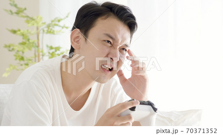 リビングでテレビゲームをする男性 リビングでテレビゲームをする男性 70371352