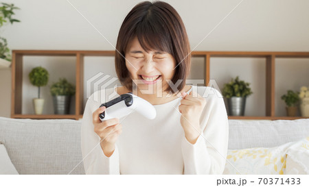 リビングでテレビゲームをする女性 リビングでテレビゲームをする女性 70371433