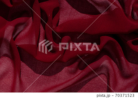 Smooth elegant burgundy chiffon fabric abstract background. Dark red wine silk luxury cloth texture light surface design Smooth elegant burgundy chiffon fabric abstract background. Dark red wine silk luxury cloth texture light surface design 70371523
