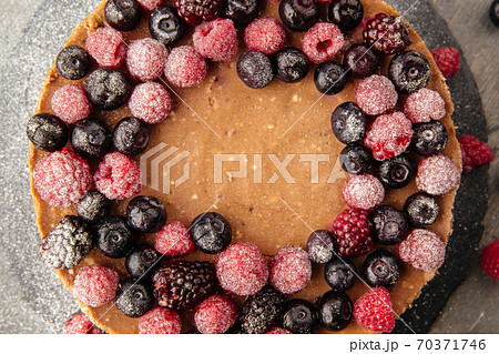 Two-layer cheesecake decorated with berries 70371746