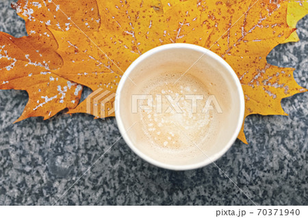 cup with leftover cappuccino coffee and yellow autumn maple leaves on marble background, copy space 70371940
