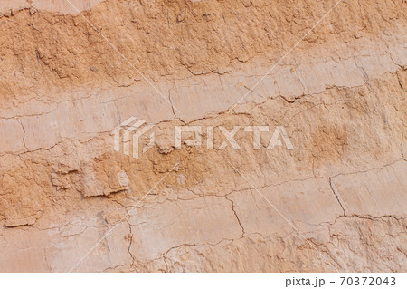 Background of great clay wall or brown ocher. Grunge rock texture Cracked ground texture in vintage style. Canyon rock. Background of great clay wall or brown ocher. Grunge rock texture Cracked ground texture in vintage style. Canyon rock. 70372043
