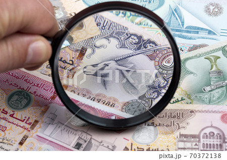 United Arab Emirates dirham in a magnifying glass United Arab Emirates dirham in a magnifying glass 70372138