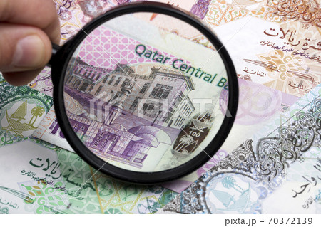 Qatari riyal in a magnifying glass a business background Qatari riyal in a magnifying glass a business background 70372139