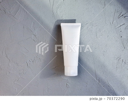 White squeezed plastic tube with trendy shadow on textured gray table. Luxury mockup cosmetic branding with copy space. 70372290