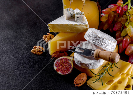 Beautiful delicious camembert cheese, parmesan, brie with grapes and figs Beautiful delicious camembert cheese, parmesan, brie with grapes and figs 70372492