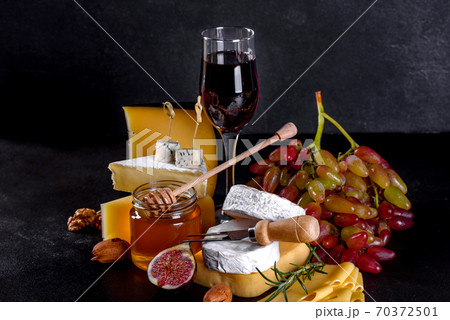Beautiful delicious camembert cheese, parmesan, brie with grapes and figs Beautiful delicious camembert cheese, parmesan, brie with grapes and figs 70372501