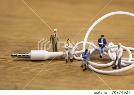 ミニプラグともつれたケーブルと話し合うビジネスマンたち 70374927