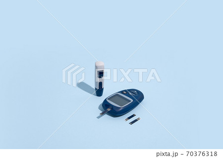 Glucose meter and pen on blue background with shadow, Metabolic syndrome concept 70376318