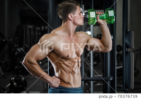 Bodybuilder drinking water after fitness workout. Bodybuilder drinking water after fitness workout. 70376739
