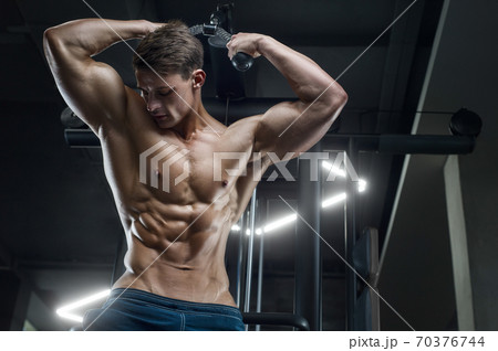 Bodybuilder strong man pumping up abs muscles Bodybuilder strong man pumping up abs muscles 70376744