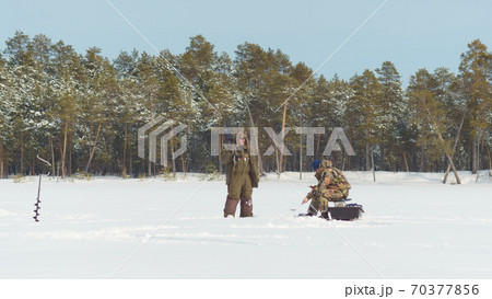 winter landscape fishermen catch fish on a frozen river 70377856