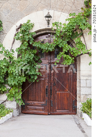 Old rural house wall with dark wooden door Old rural house wall with dark wooden door 70381624