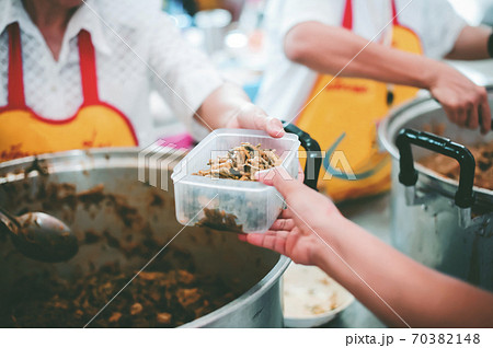 Volunteers serving food for poor people Volunteers serving food for poor people 70382148