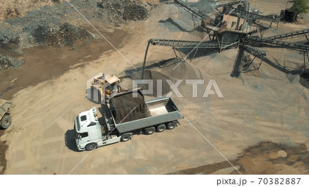 Excavator is pouring the coal into the truck. 70382887