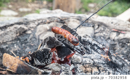 Sausage roasted over an almost extinguished fire Sausage roasted over an almost extinguished fire 70382958