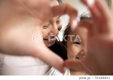 Close up Asian mother and little daughter making heart gesture 70388841