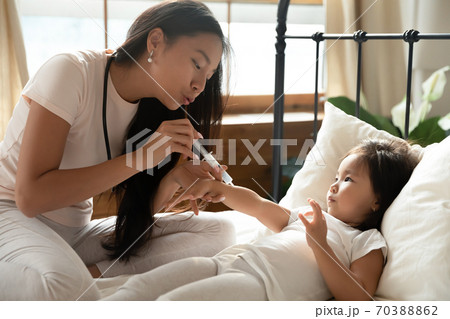 Loving Asian mother and little girl playing doctor together Loving Asian mother and little girl playing doctor together 70388862