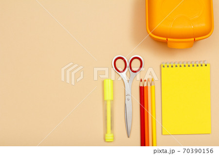Felt pen, scissors, color pencils, lunch box and notebook on beige background 70390156