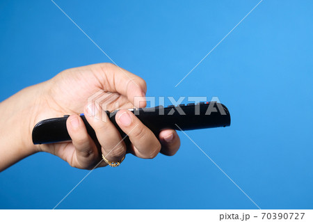 close up of women hand holding tv remote. close up of women hand holding tv remote. 70390727