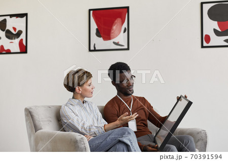 Art Experts Discussing Paintings in Gallery 70391594