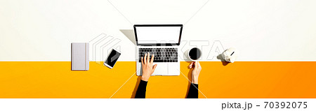 Person using a laptop computer with a piggy bank Person using a laptop computer with a piggy bank 70392075