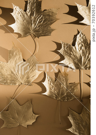 Autumn composition. Pattern made of autumn golden marple leaves on nude color background. Flat lay, top view, copy space Autumn composition. Pattern made of autumn golden marple leaves on nude color background. Flat lay, top view, copy space 70392612
