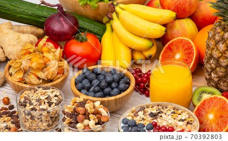 Group Fruits Breakfast mixed vegetables with salad bowl, nuts bowl, strawberry, banana, and pineapple, orange juice,  vitamin c in food  nature for health and diet in the top view on the wood table. 70392803