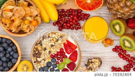 Group Fruits Breakfast mixed vegetables with salad bowl, nuts bowl, strawberry, banana, and pineapple, orange juice,  vitamin c in food  nature for health and diet in the top view on the wood table. 70392804