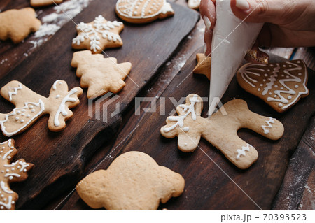 Decorating gingerbread cookie with sugar icing Decorating gingerbread cookie with sugar icing 70393523