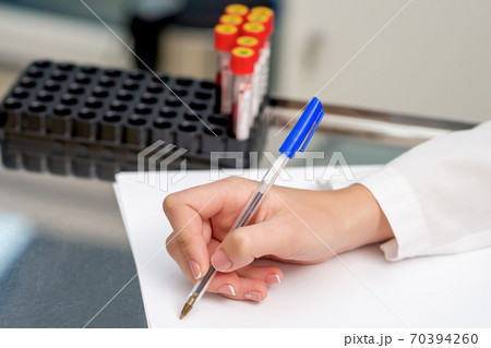 Doctor is writing test results. 70394260